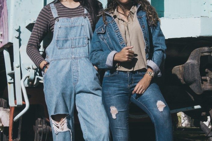 two people wearing denim in front of a truck
