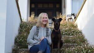 Sam Stanley of A Coastal Plot sat on steps with her dog