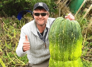 Dan of Allotment Diary with a large vegetable smiling and giving a thumbs up
