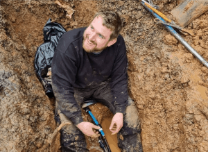 Kev of An English Homestead sat in a trench smiling